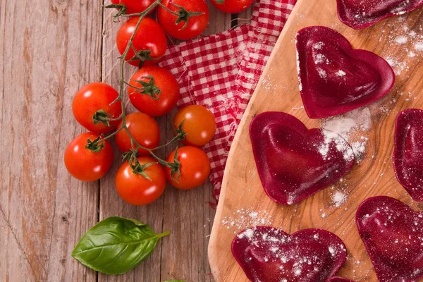 Red heart ravioli with tomato, mozzarella and basil.