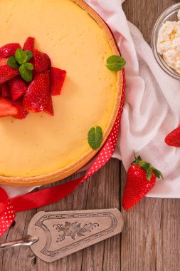 ahşap masa üzerinde çilekli cheesecake.