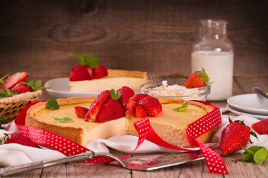 ahşap masa üzerinde çilekli cheesecake.