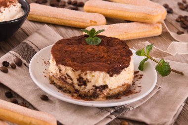 Beyaz çanak üzerinde mascarpone peyniri ile Tiramisu.
