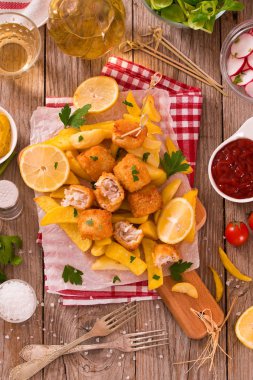 Balık ve cips kesme tahtası üzerinde.