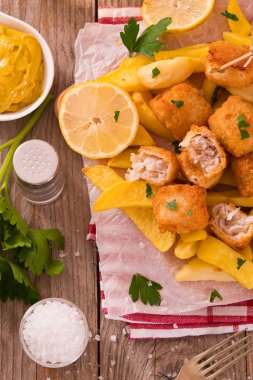 Balık ve cips kesme tahtası üzerinde.