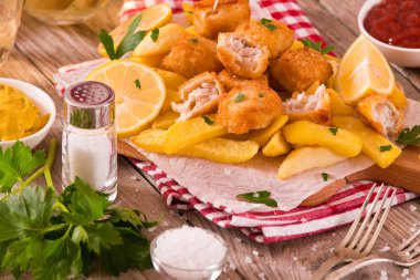 Balık ve cips kesme tahtası üzerinde.