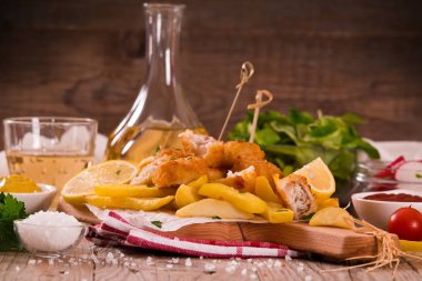 Balık ve cips kesme tahtası üzerinde.