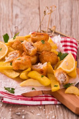 Balık ve cips kesme tahtası üzerinde.