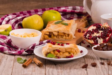 Apple strudel beyaz çanak üzerinde narlı.