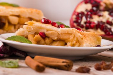 Apple strudel beyaz çanak üzerinde narlı.