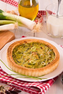 Beyaz çanak üzerinde ekşi krem ile Leek quiche.