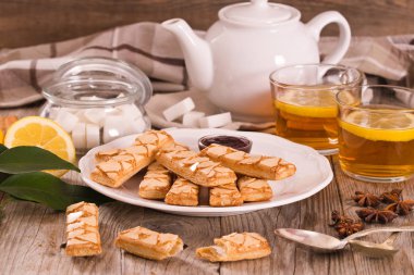 Beyaz çanak üzerinde reçel ile Puf böreği çerezleri.