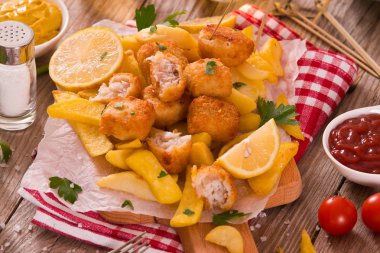 Balık ve cips kesme tahtası üzerinde.