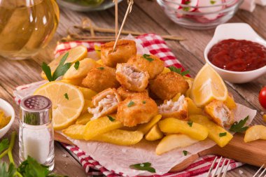 Balık ve cips kesme tahtası üzerinde.