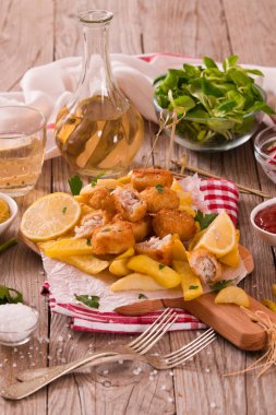 Balık ve cips kesme tahtası üzerinde.