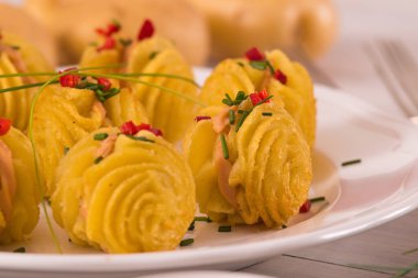 Düşes patates sandviç beyaz çanak üzerinde.