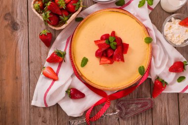 Ahşap masa üzerinde nane ile Çilek cheesecake.