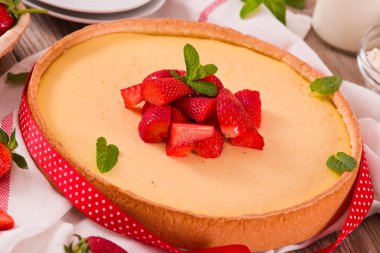 Ahşap masa üzerinde nane ile Çilek cheesecake.