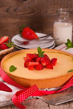 Ahşap masa üzerinde nane ile Çilek cheesecake.