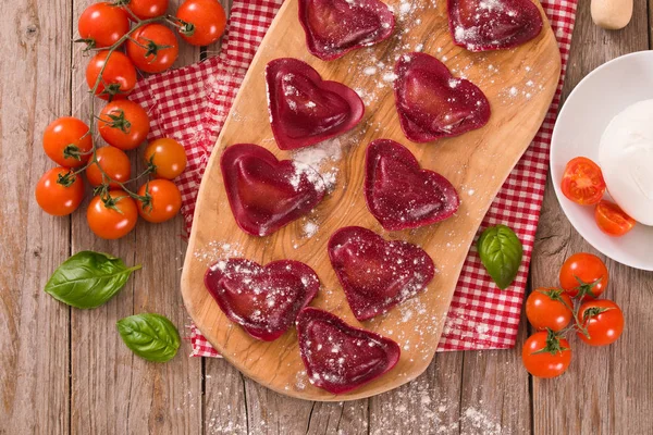 Red heart ravioli with tomato, mozzarella and basil.