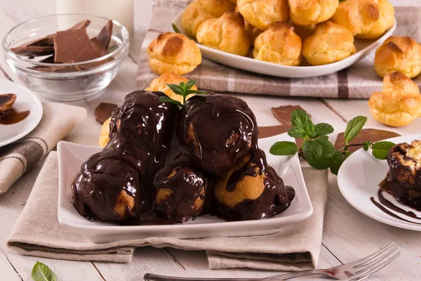 Chocolate Profiteroles Bitą Śmietaną Białym Naczyniu — Zdjęcie stockowe