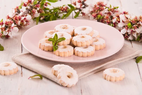 Canestrelli biscuits with icing sugar on wooden table.
