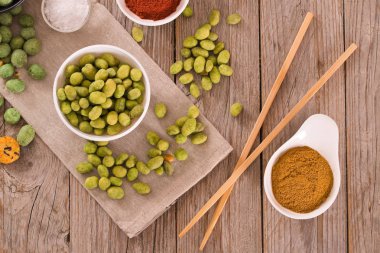 Ahşap masada baharat ile Wasabi kaplı fıstık.