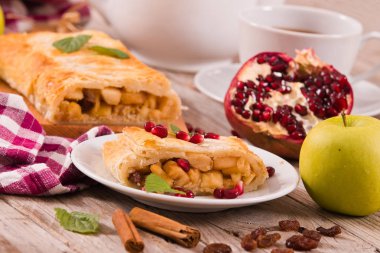 Apple strudel beyaz çanak üzerinde narlı.