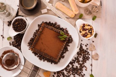 Beyaz çanak üzerinde kahve fasulyesi ile tirayisu kek.