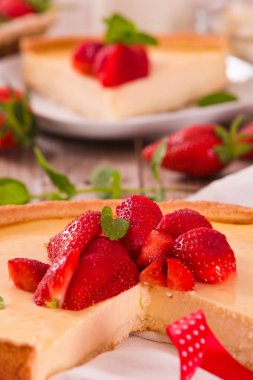 Ahşap masa üzerinde nane ile Çilek cheesecake.
