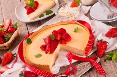 Ahşap masa üzerinde nane ile Çilek cheesecake.