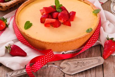 Ahşap masa üzerinde nane ile Çilek cheesecake.