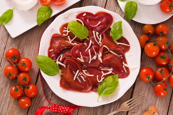 Red heart ravioli with tomato, mozzarella and basil.
