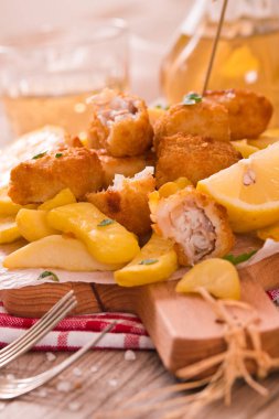 Kesme tahtası üzerinde maydanoz ile balık ve cips.