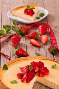 Ahşap masa üzerinde nane ile Çilek cheesecake.