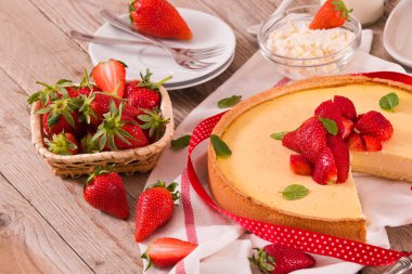 Ahşap masa üzerinde nane ile Çilek cheesecake.
