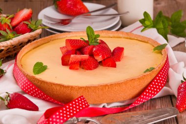 Ahşap masa üzerinde nane ile Çilek cheesecake.