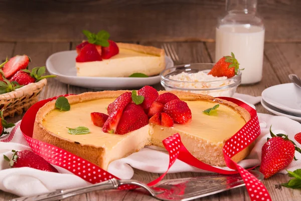 Ahşap masa üzerinde nane ile Çilek cheesecake.