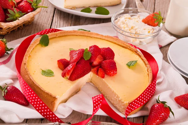 Ahşap masa üzerinde nane ile Çilek cheesecake.