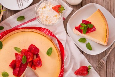 Ahşap masa üzerinde nane ile Çilek cheesecake.