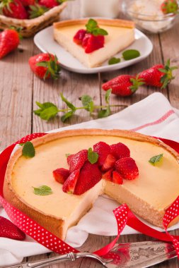 Ahşap masa üzerinde nane ile Çilek cheesecake.