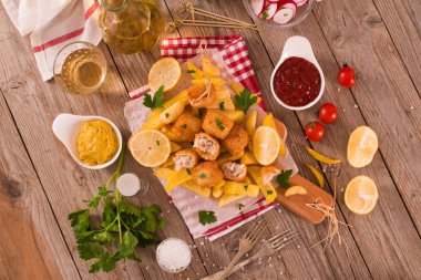 Kesme tahtası üzerinde soslu balık ve cips.