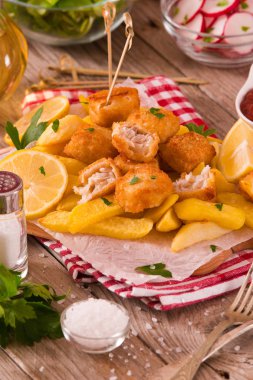 Kesme tahtası üzerinde soslu balık ve cips.