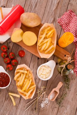 Ahşap masada soslu patates kızartması..