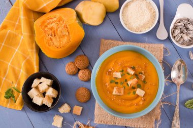 Mavi tabakta patatesli balkabağı kremalı çorba.