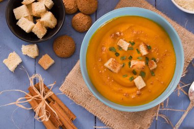 Mavi tabakta patatesli balkabağı kremalı çorba.