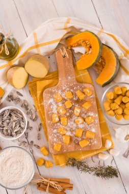 Kesme tahtasında patates olan çiğ balkabağı gnocchi..