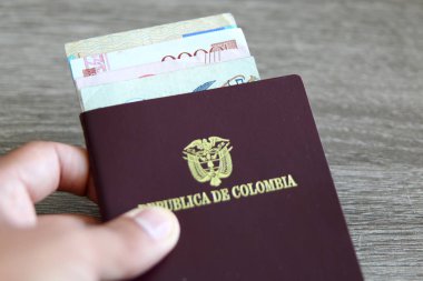 Banka notları açık gri ahşap arka planı üzerinde ile Kolombiya pasaportu