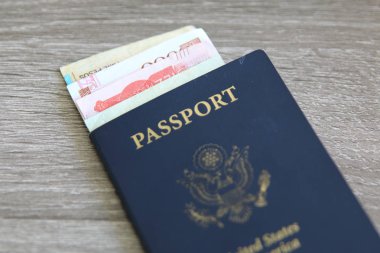 Banka notları açık gri ahşap arka planı üzerinde ile Amerikan pasaportu