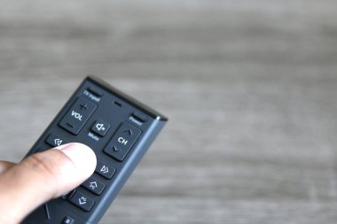 bir uzaktan kumanda ile kanalları açık gri arka planı üzerinde değişen el