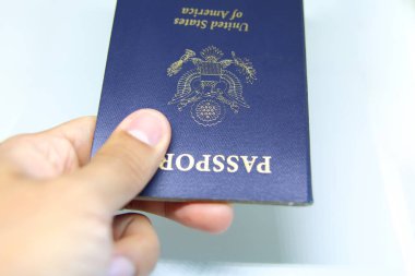 Bir pasaport beyaz bir arka plan üzerinde tutan bir kişi el görüntüsünü