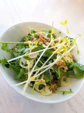 taze ve süslü salata bir kase içinde gri bir ahşap arka plan üzerinde