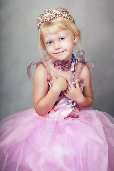 美しい少女彼女の手で王冠を穴かがりのピンクのドレスのリトル プリンセス — ストック写真